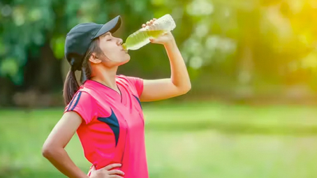 Woman in sport clothing drinking elecrolites